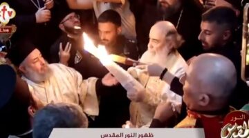 بطريرك القدس يخرج بالشعلة المضيئة من كنيسة القيامة عقب ظهور النور المقدس